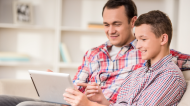 A foster carer looking at the TACT website with his son