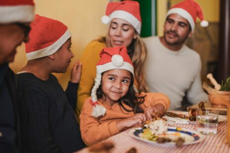 Foster carers and children eating a Christmas meal