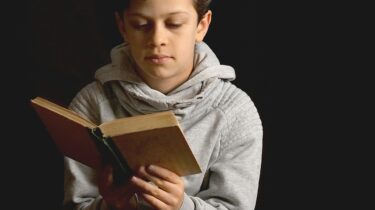 A young person reading books about fostering