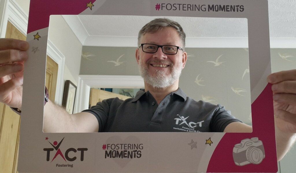 Richard holding a fostering moments photo frame, for foster care fortnight